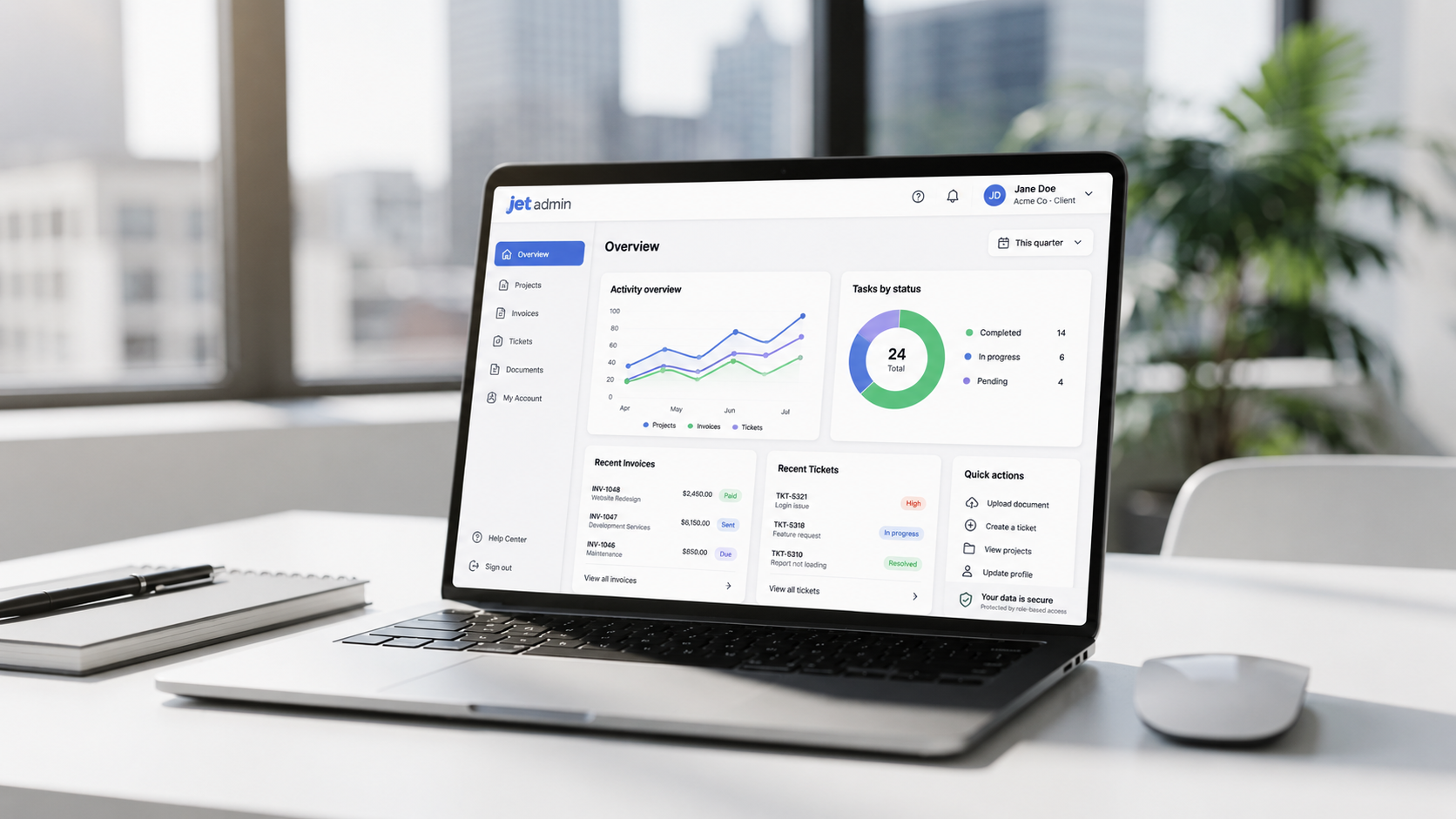 The image features a modern laptop showcasing a clean dashboard interface filled with charts, lists, and a navigation sidebar, set in a bright office environment. This user-friendly layout exemplifies a client portal software designed for project management, enabling effective client communication and task management in a collaborative workspace.