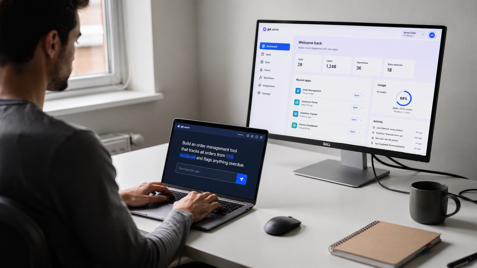 A person is typing a natural language prompt into a laptop at a modern desk, with a second monitor displaying a web application interface that suggests features of an AI app builder. The scene highlights the ease of app development for non-technical users, showcasing the potential for generating functional apps through simple prompts.
